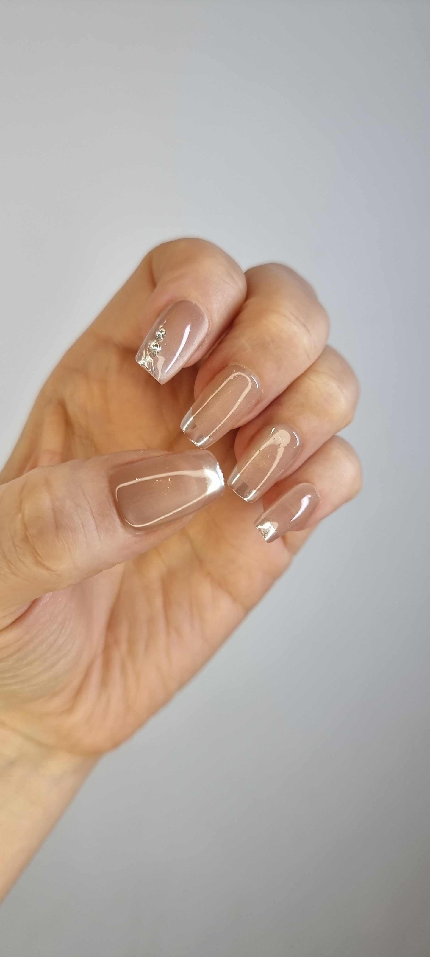 A hand with a full set of almond-shaped Nahla press-on nails.