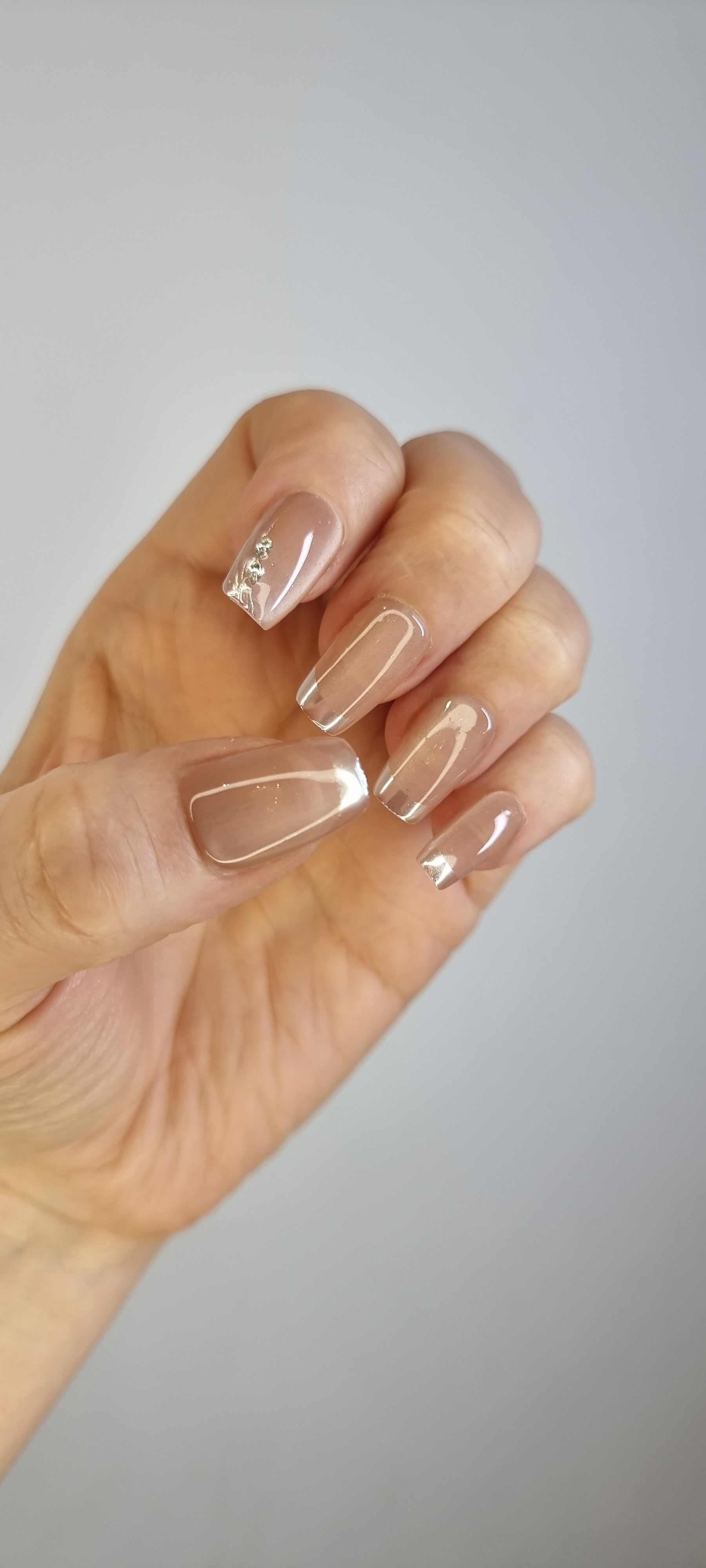 A hand with a full set of almond-shaped Nahla press-on nails.