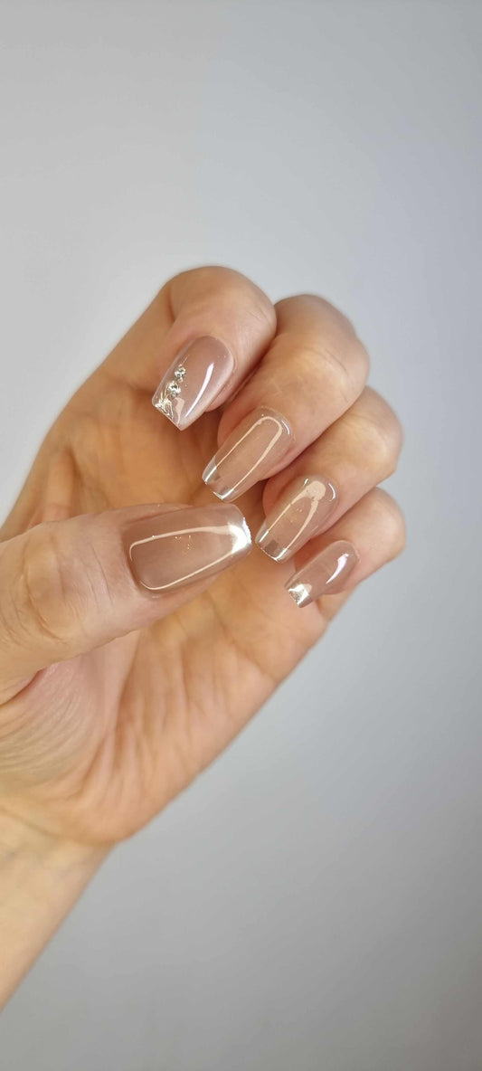 A hand with a full set of almond-shaped Nahla press-on nails.