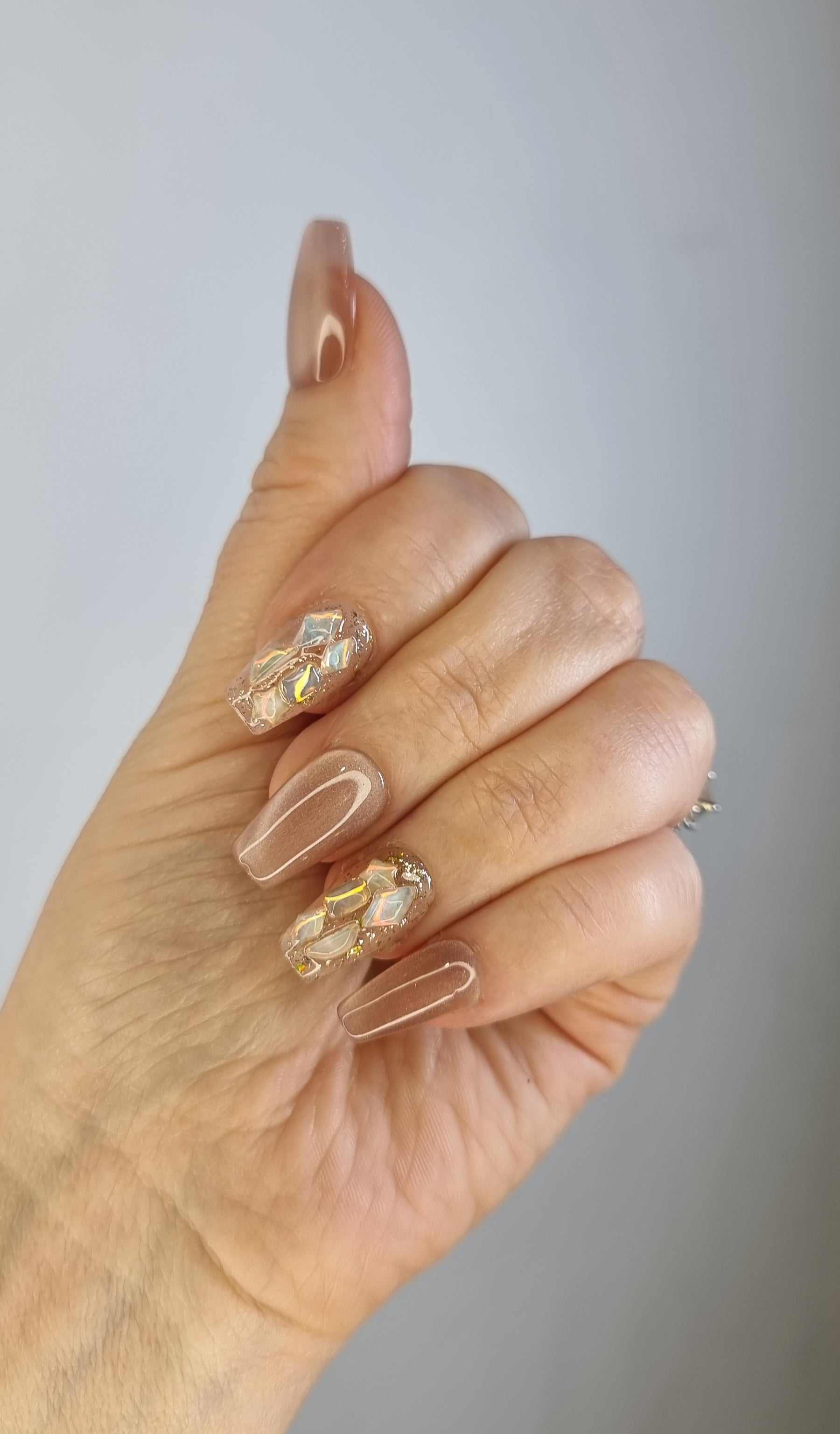 Close-up of a hand with long, almond-shaped Najma press-on nails.
