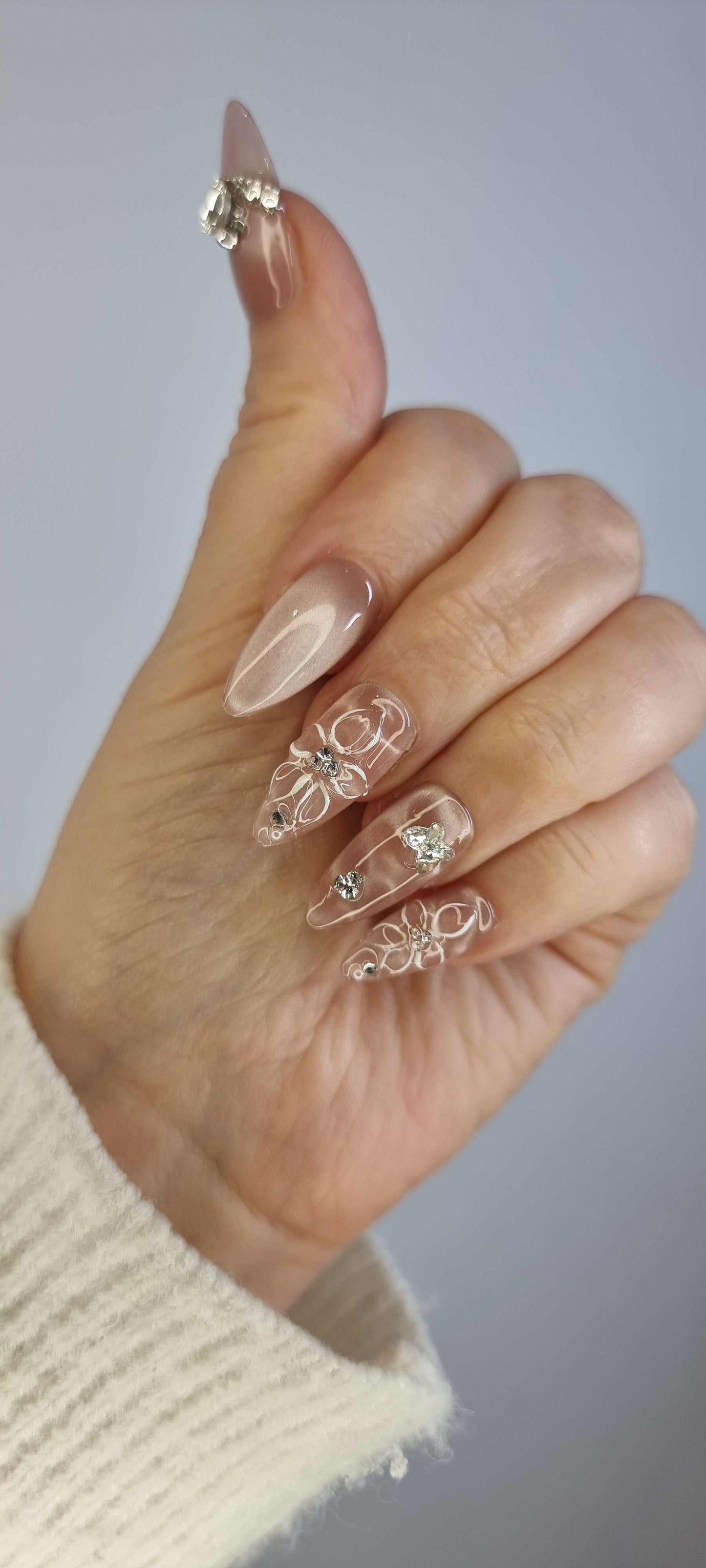 Hand wearing Noor press-on nails, applied professionally by Nail Addict.