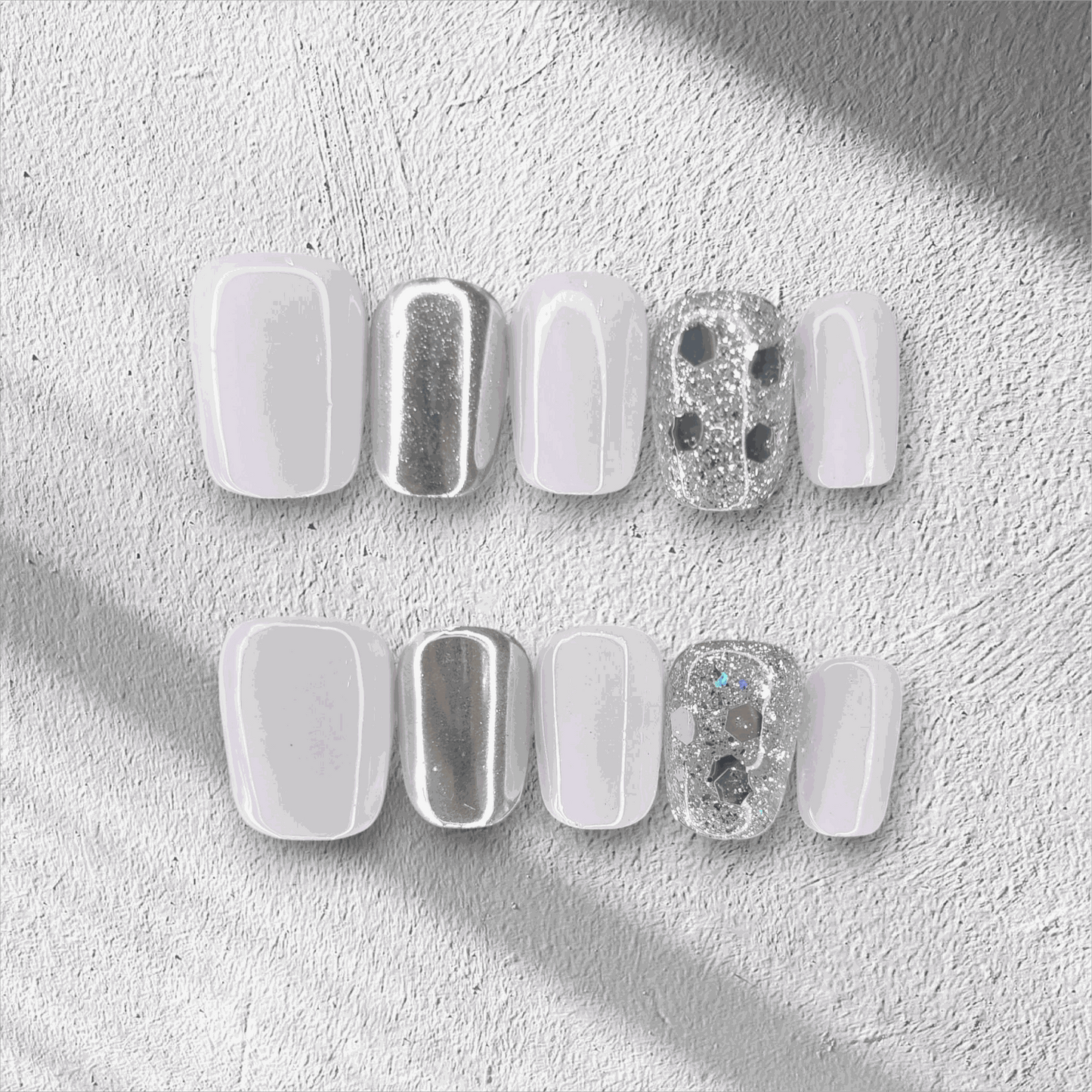 A flat lay of the glossy, square-shaped Oman Opulence press-on nail set in the box.