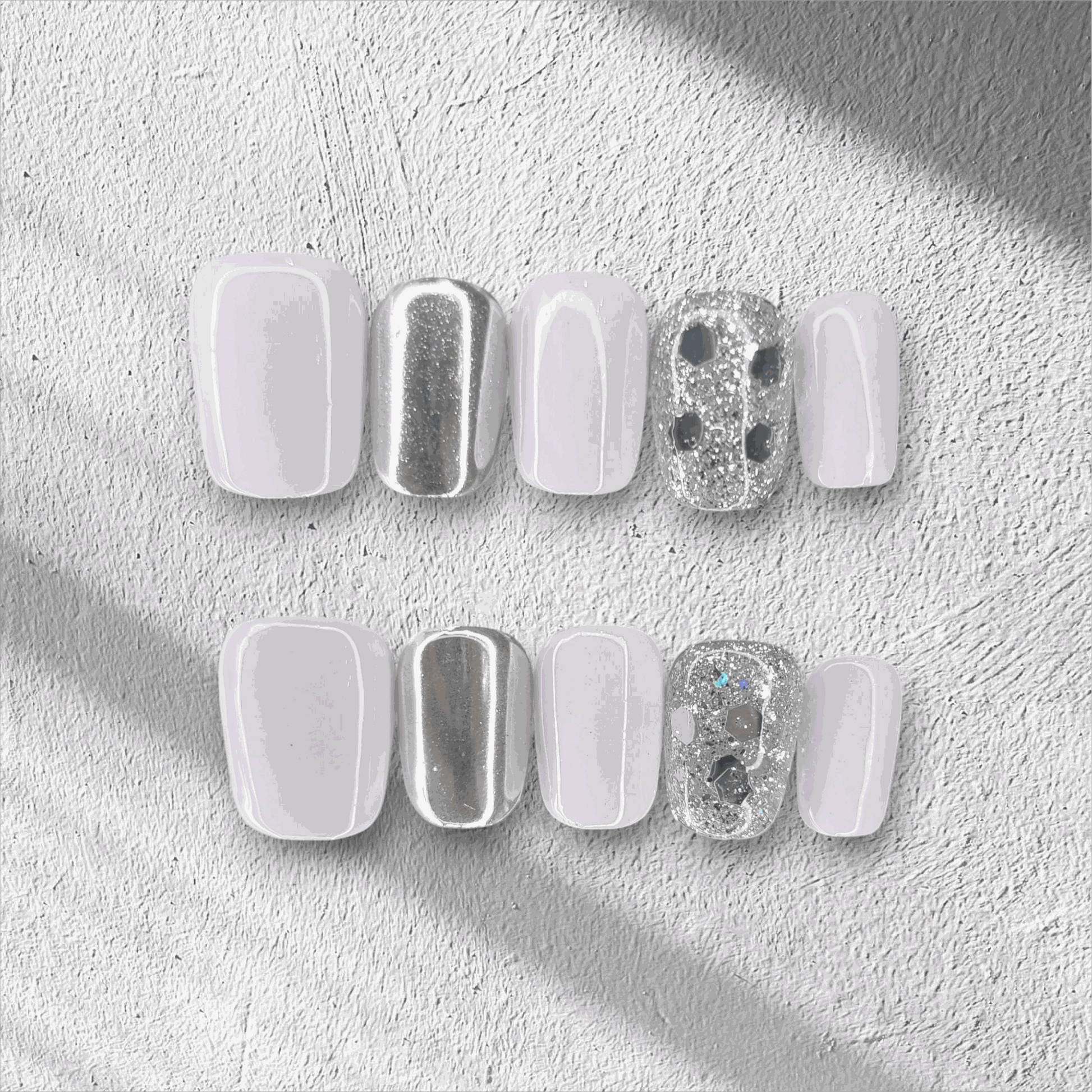 A flat lay of the glossy, square-shaped Oman Opulence press-on nail set in the box.