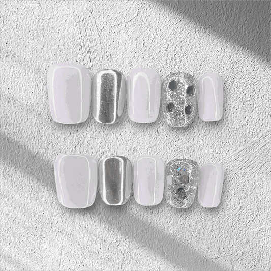 A flat lay of the glossy, square-shaped Oman Opulence press-on nail set in the box.