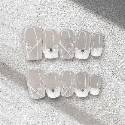 Full set of Pearl of Qatar press-on nails in a square shape, displayed in the box.