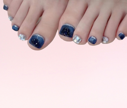 A pair of feet showing the vibrant, colorful Naaz pedi press-on toe nails set.