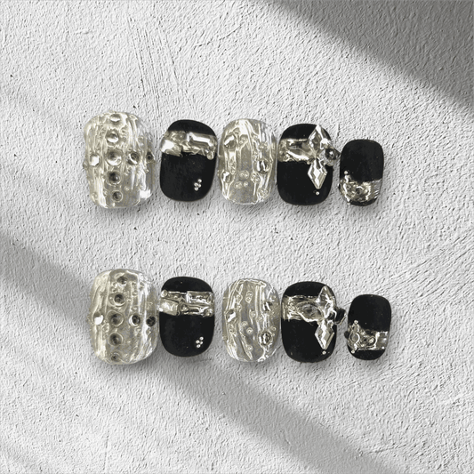 Full set of black and silver glossy press-on nails from the Qatar Elegance collection displayed in the box.