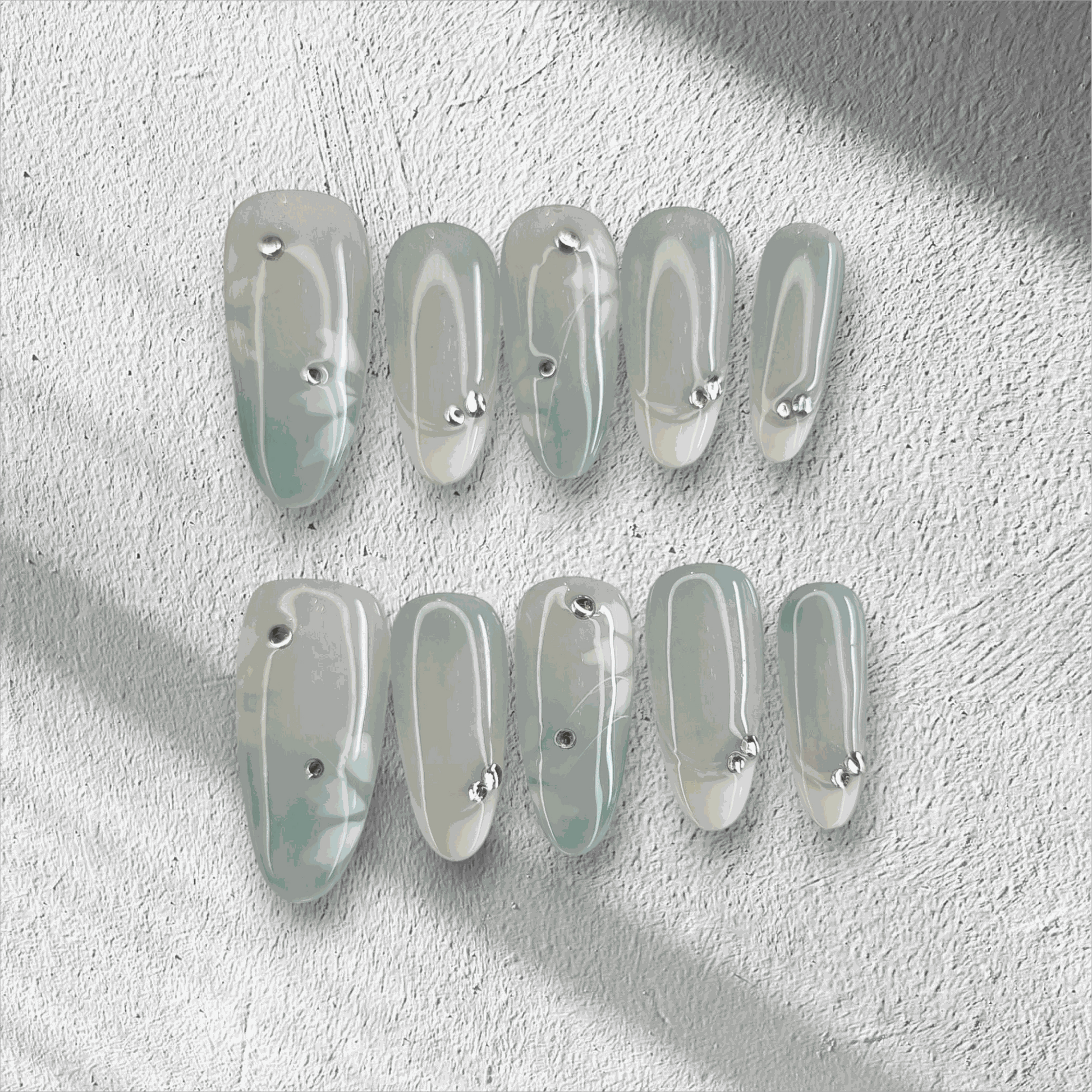 Full set of glossy, translucent off-white Rawan press-on nails displayed in the box.