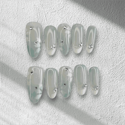 Full set of glossy, translucent off-white Rawan press-on nails displayed in the box.