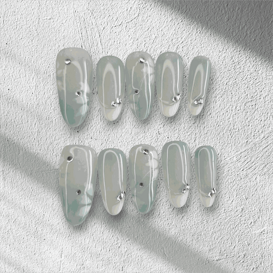 Full set of glossy, translucent off-white Rawan press-on nails displayed in the box.