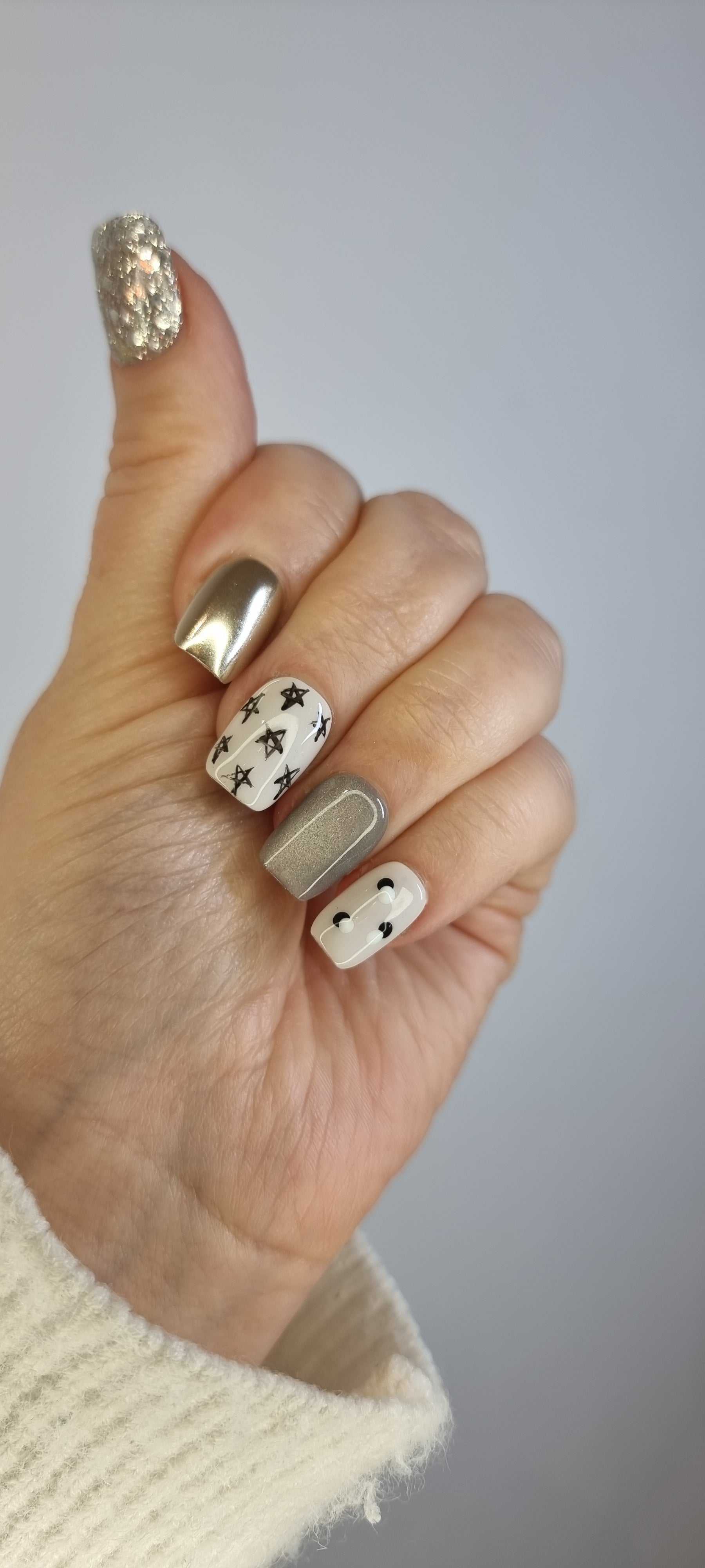 Set of Reemisland glossy, neutral-toned press-on nails, showing design details.