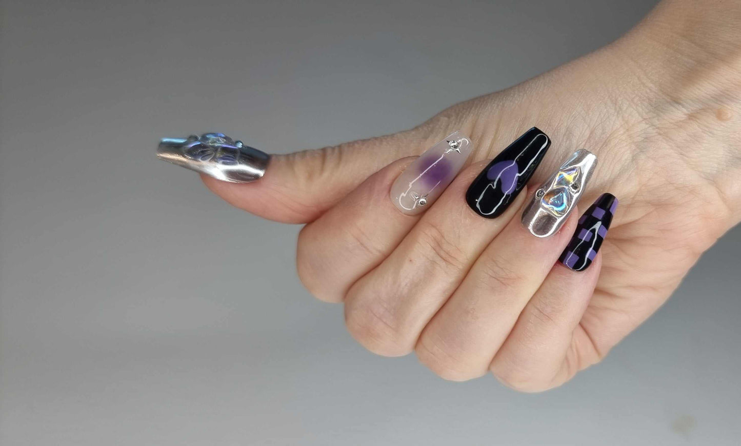 Set of Riyadh Radiance silver, glossy, and black press-on nails, showing design variation.