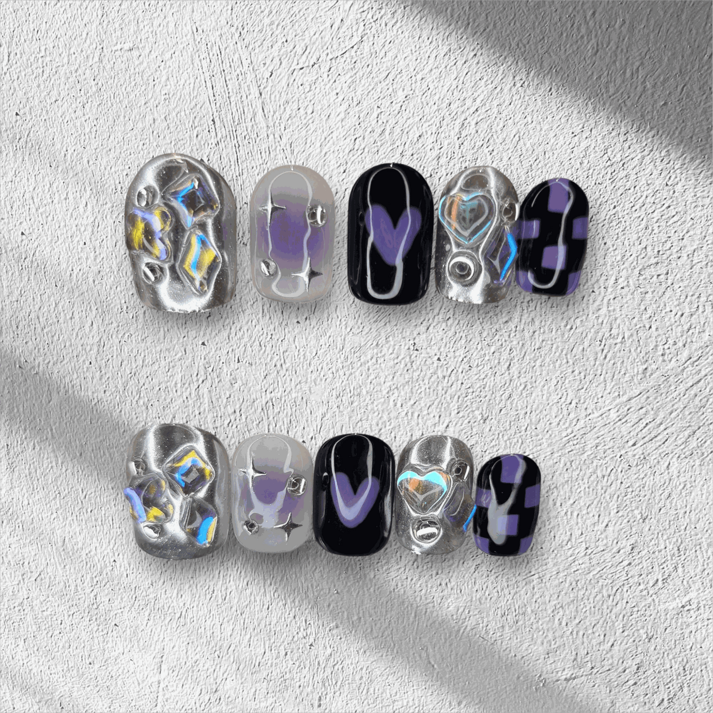 Set of silver, glossy, and black Riyadh Radiance press-on nails, an elegant contrasting design.