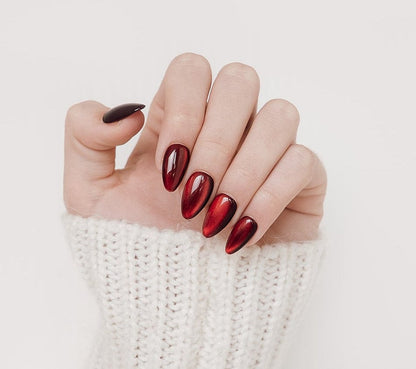 Hand with red nail polish on a white background