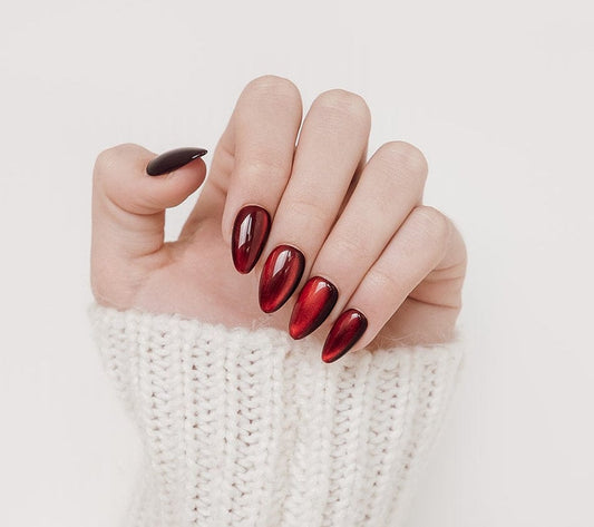 Hand with red nail polish on a white background