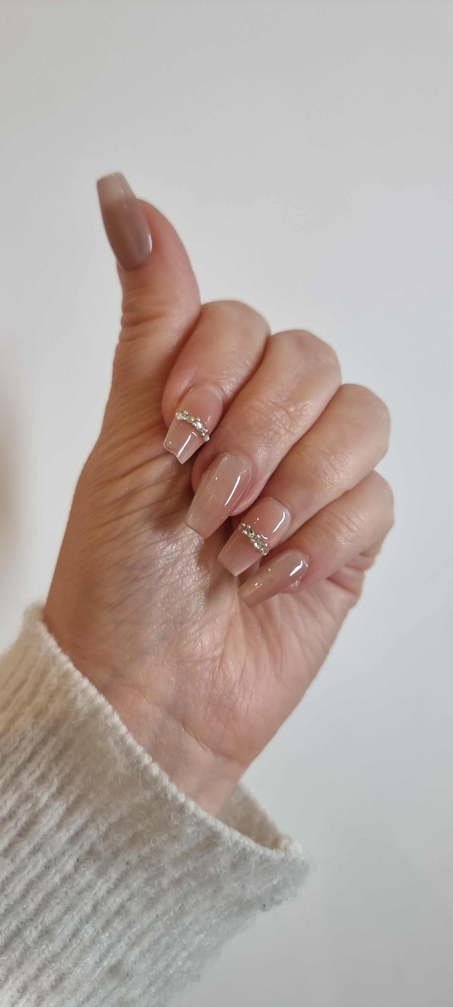 Hand wearing Sabah press-on nails, applied professionally by Nail Addict.