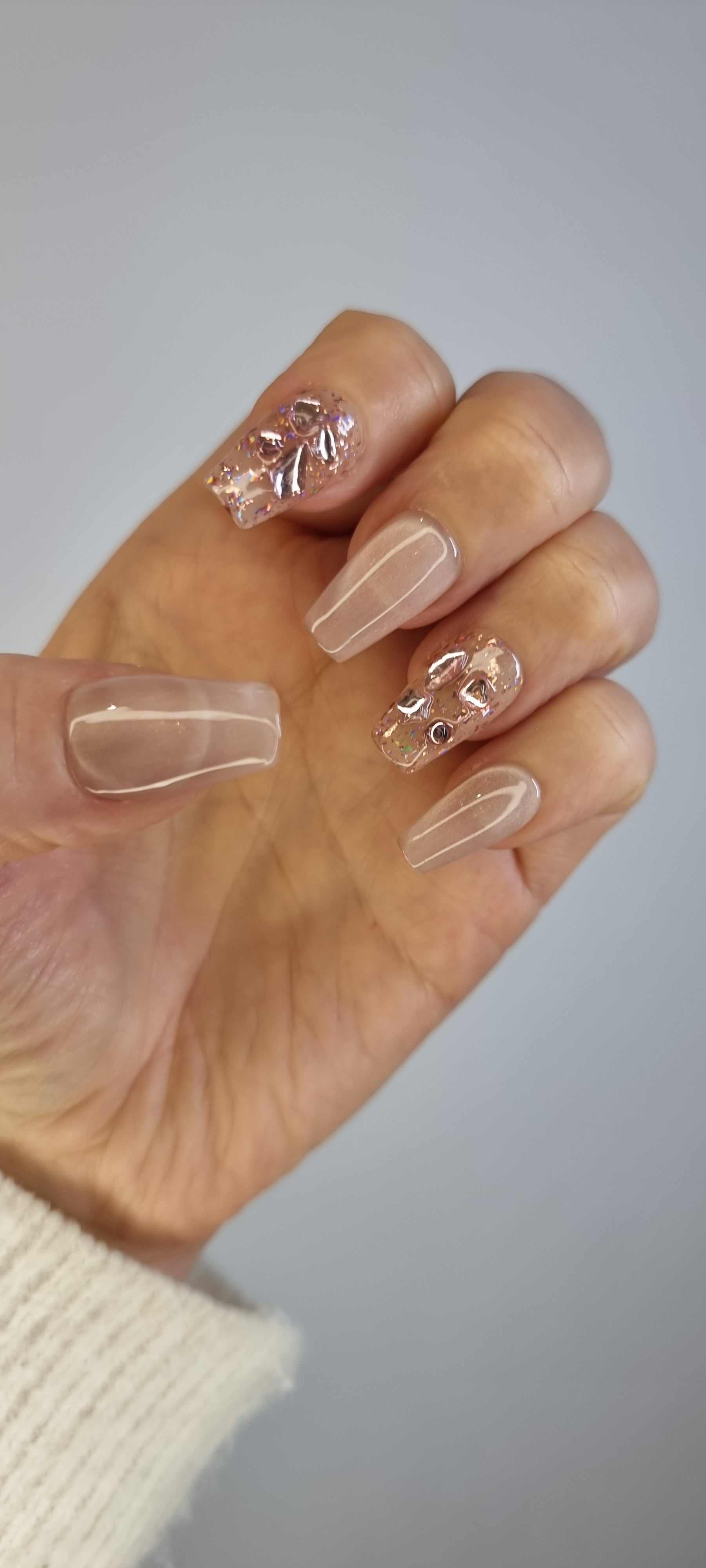 Close-up of Sadeen nude press-on nails showing the glossy finish.