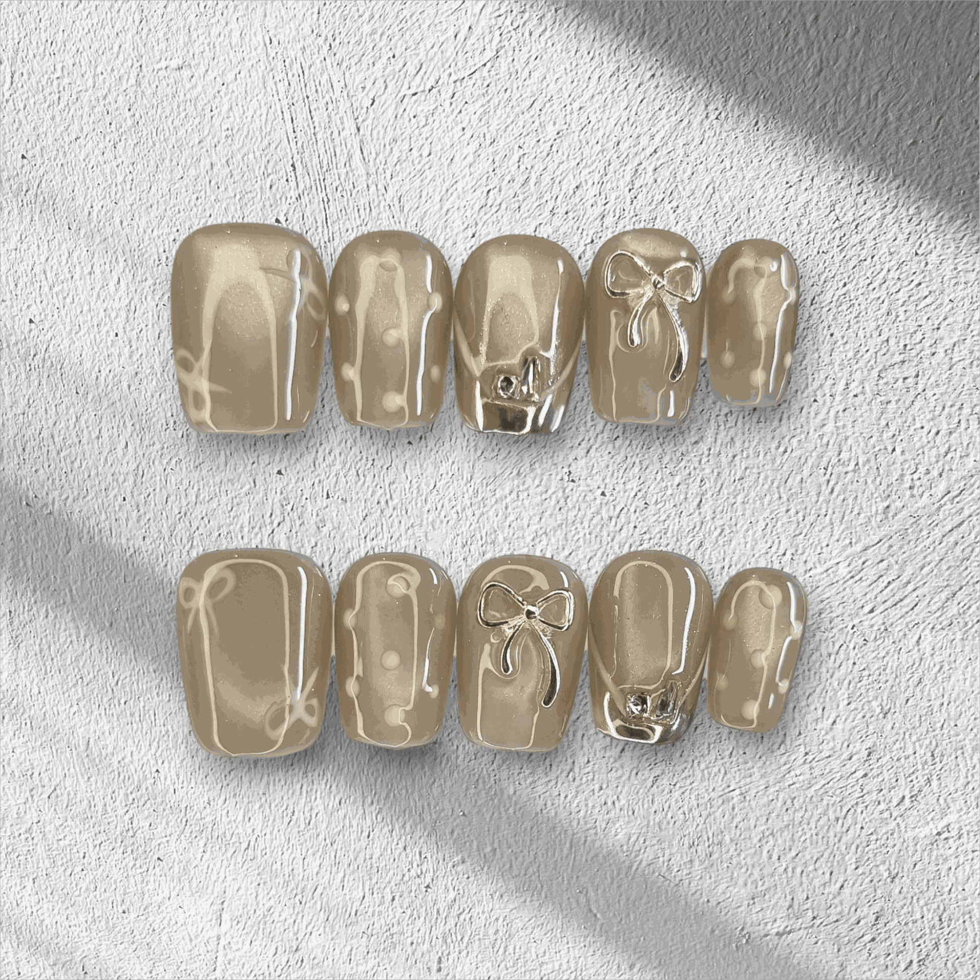 Full set of Sahara false nails with a metallic champagne color, displayed in the box.