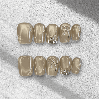 Full set of Sahara false nails with a metallic champagne color, displayed in the box.