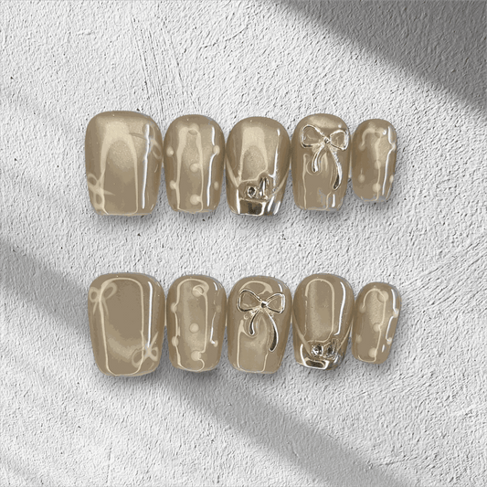 Full set of Sahara false nails with a metallic champagne color, displayed in the box.