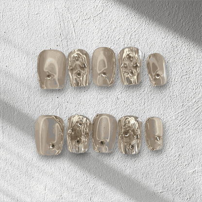 Full set of metallic gold, coffin-shaped Sama Short press-on nails displayed in the box.