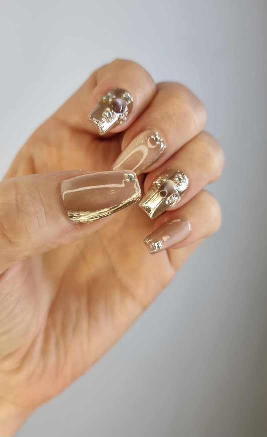Close-up of the Sama metallic gold, long coffin-shaped press-on nails.