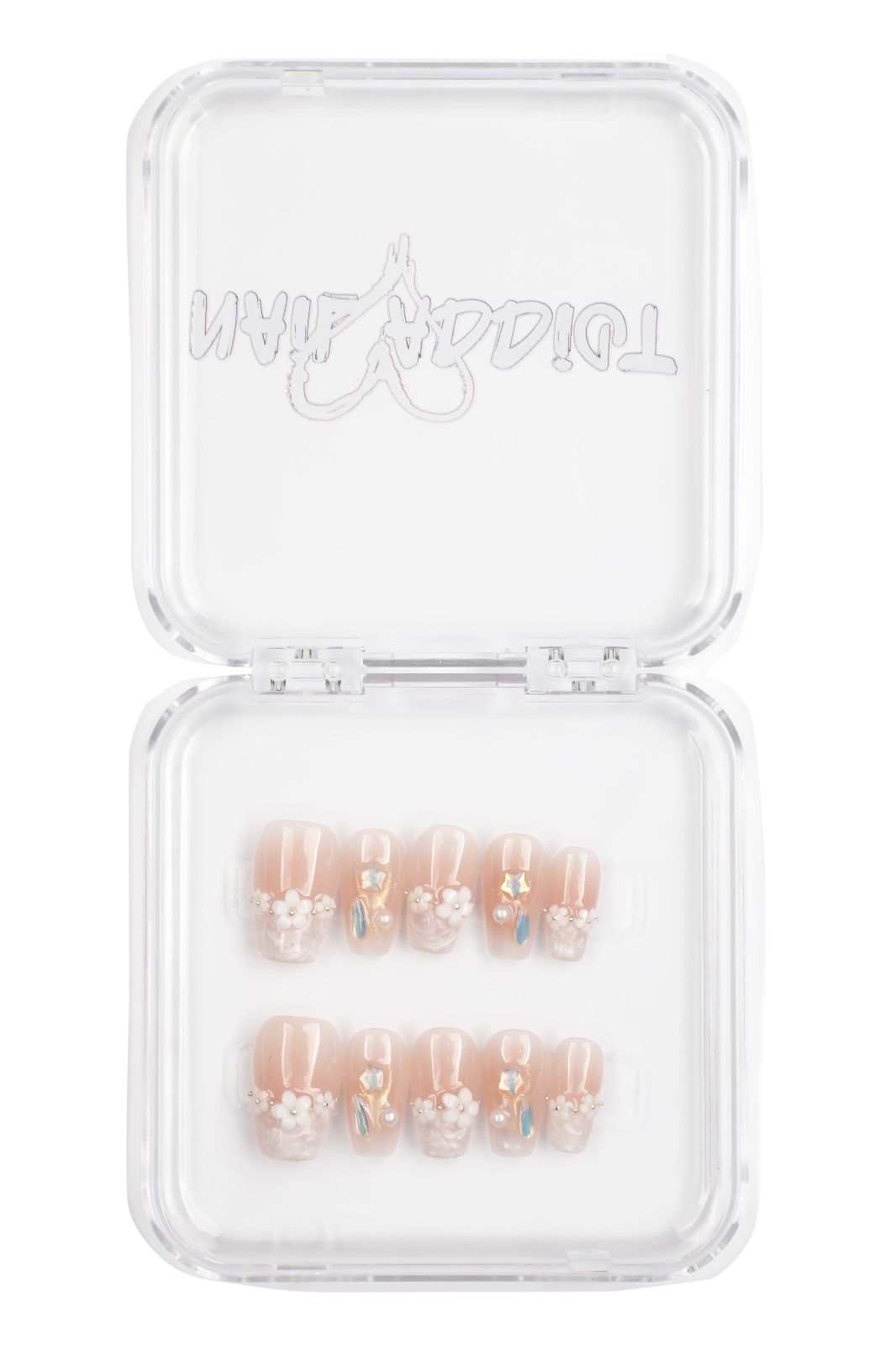Selina sheer pink and white short square press-on nails by Nail Addict, with a heart charm accent.