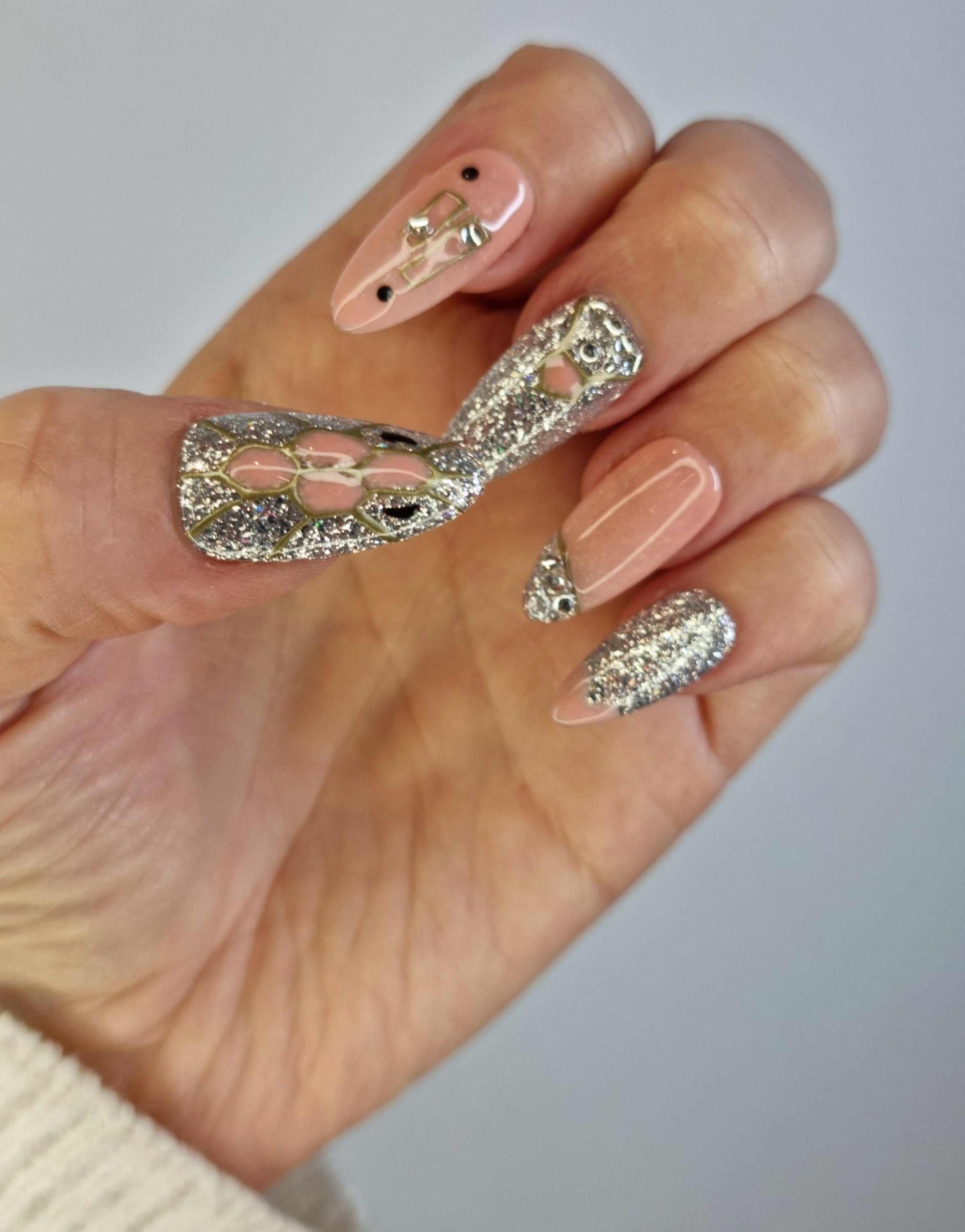 A hand wearing the Sharjah Sparkle nude almond-shaped press-on nails.