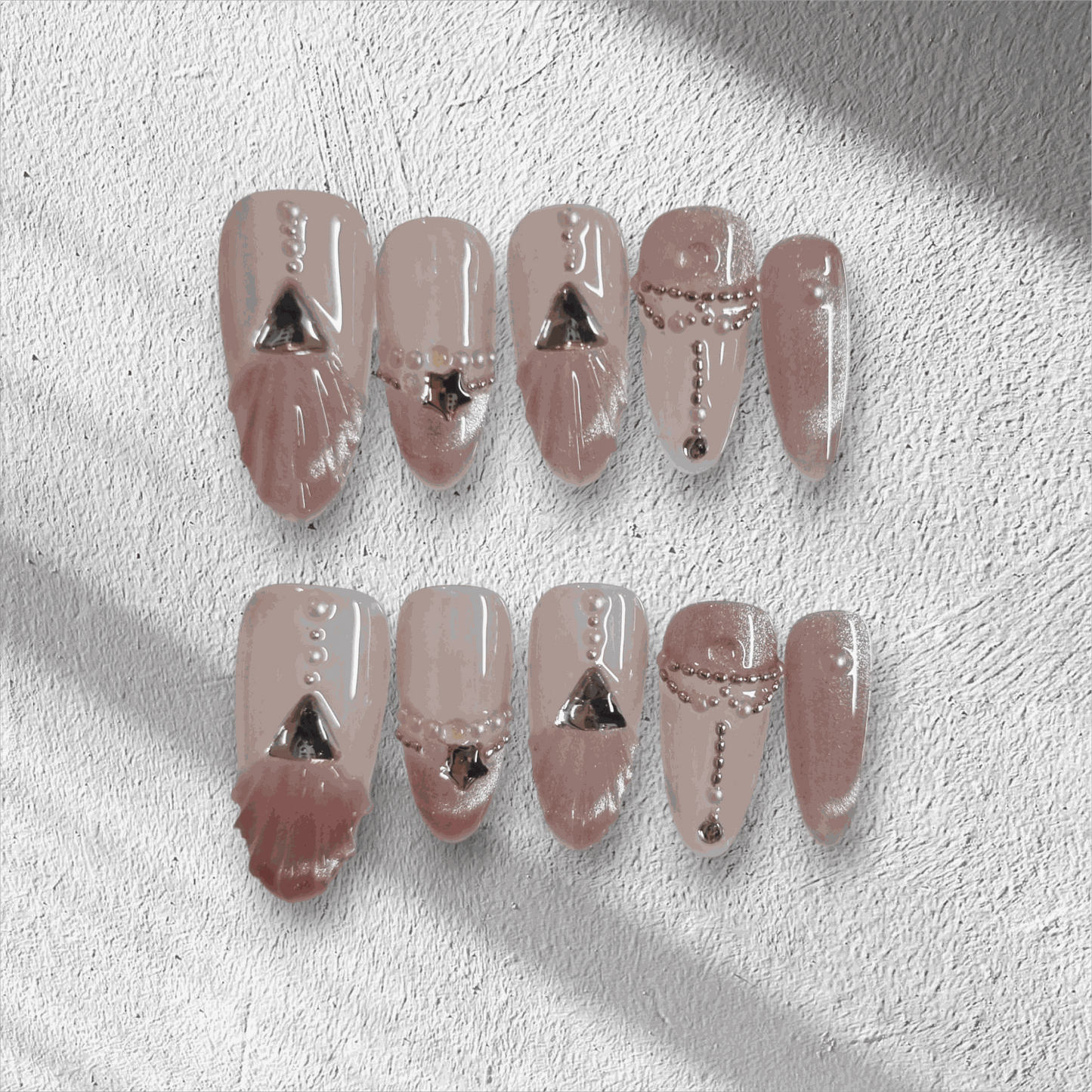 Full set of Sharqiya Shine nude, almond-shaped press-on nails displayed in the box.