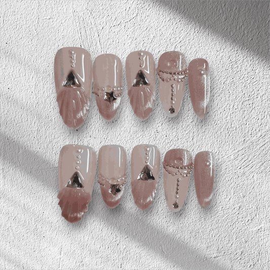 Full set of Sharqiya Shine nude, almond-shaped press-on nails displayed in the box.