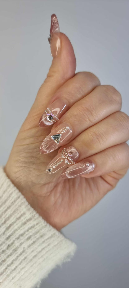 Close-up of Sharqiya Shine nude, almond-shaped press-on nails.