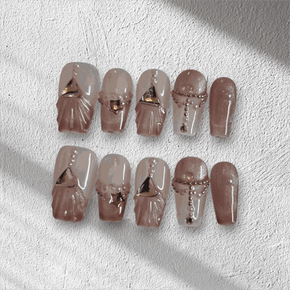 Full set of Sharqiya Shine nude, coffin-shaped press-on nails displayed in the box.