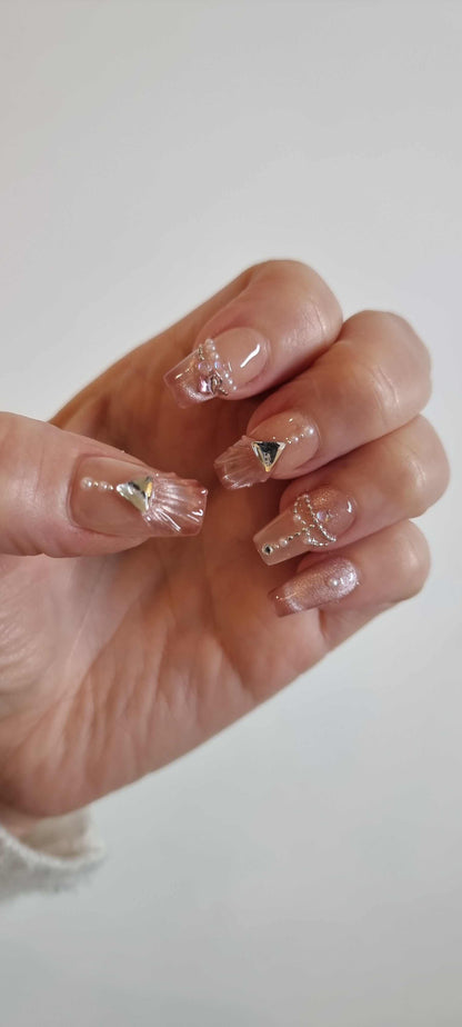 Close-up of Sharqiya Shine nude, coffin-shaped press-on nails.
