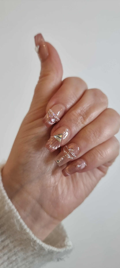 Set of Sharqiya Shine nude, coffin-shaped press-on nails, showing the finished look.