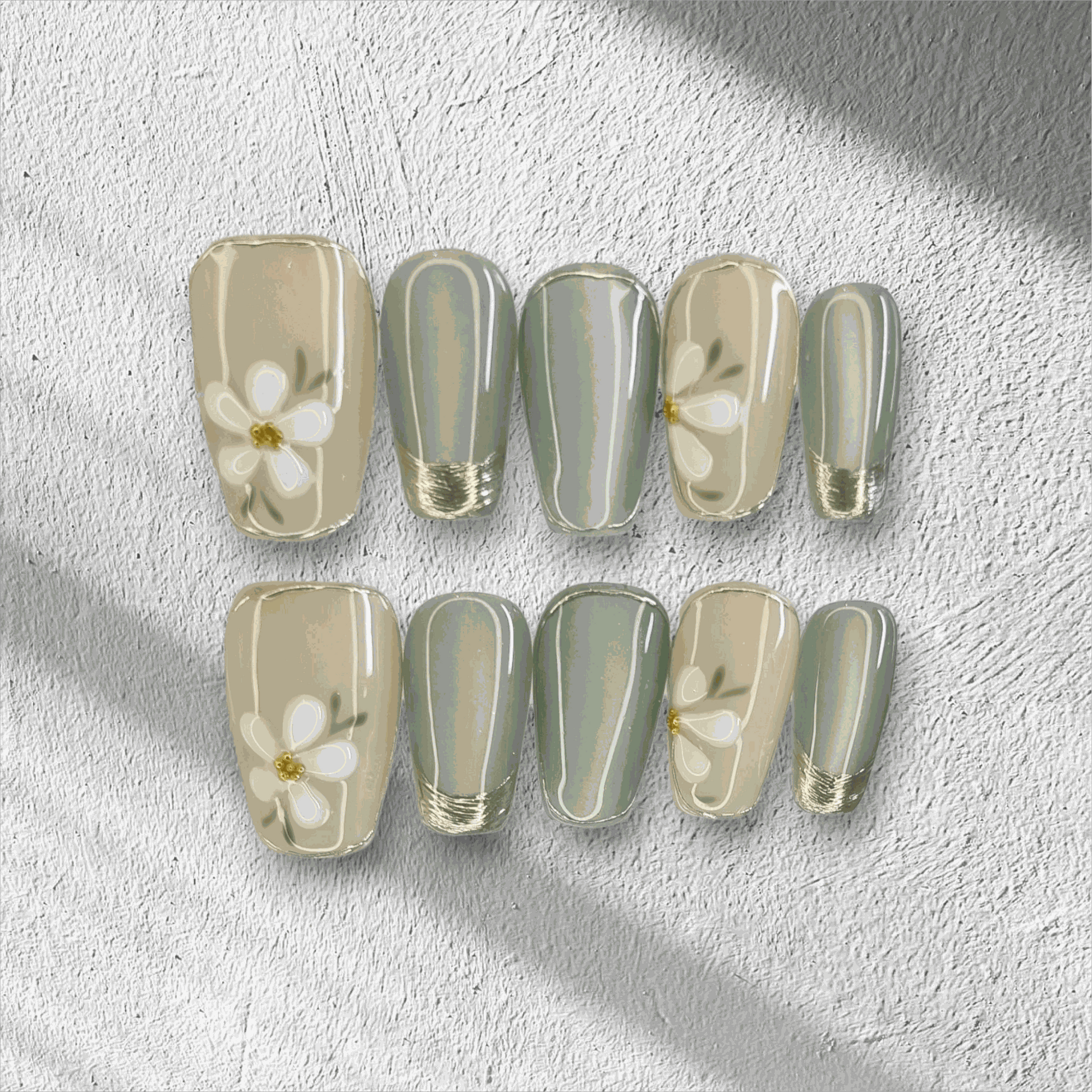 Full set of Tala cream and gold short square press-on nails, displayed in packaging.