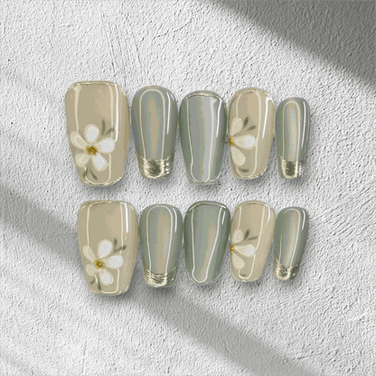 Full set of Tala cream and gold short square press-on nails, displayed in packaging.