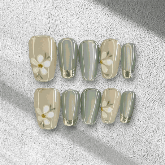 Full set of Tala cream and gold short square press-on nails, displayed in packaging.