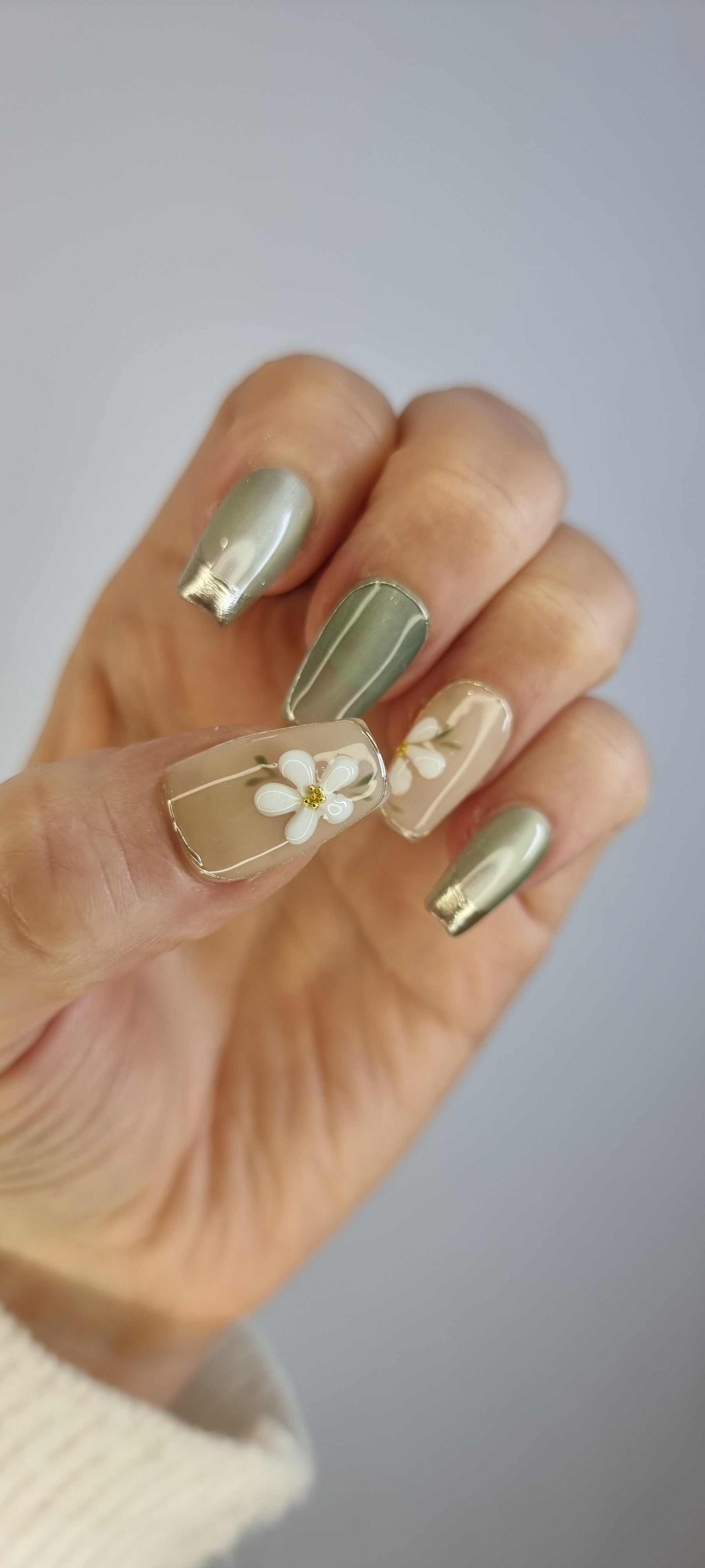 Hand wearing Tala cream and gold short square press-on nails, showing the finished look.