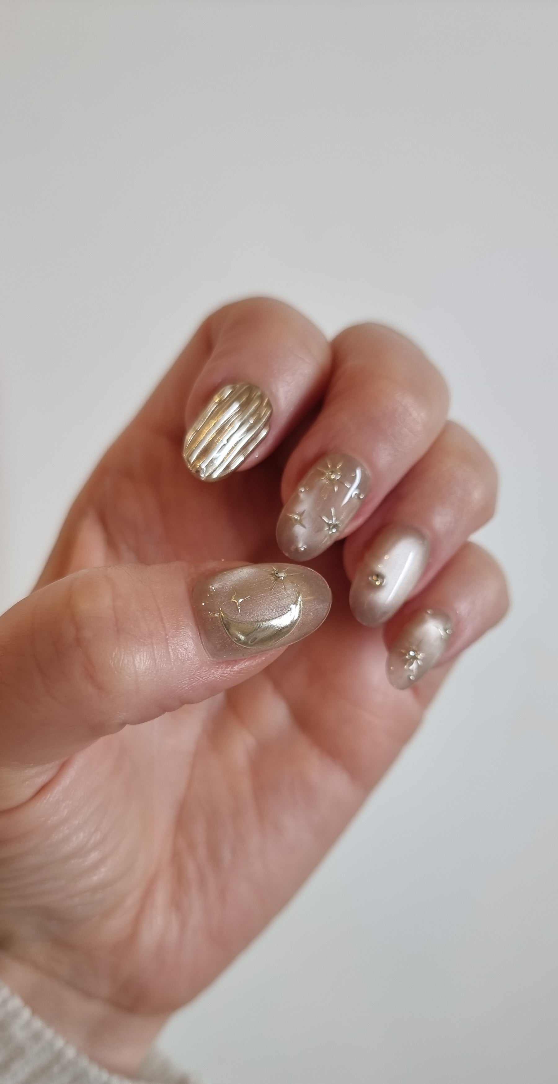 Set of glossy, light-toned UAE Glow press-on nails with a subtle shimmer.