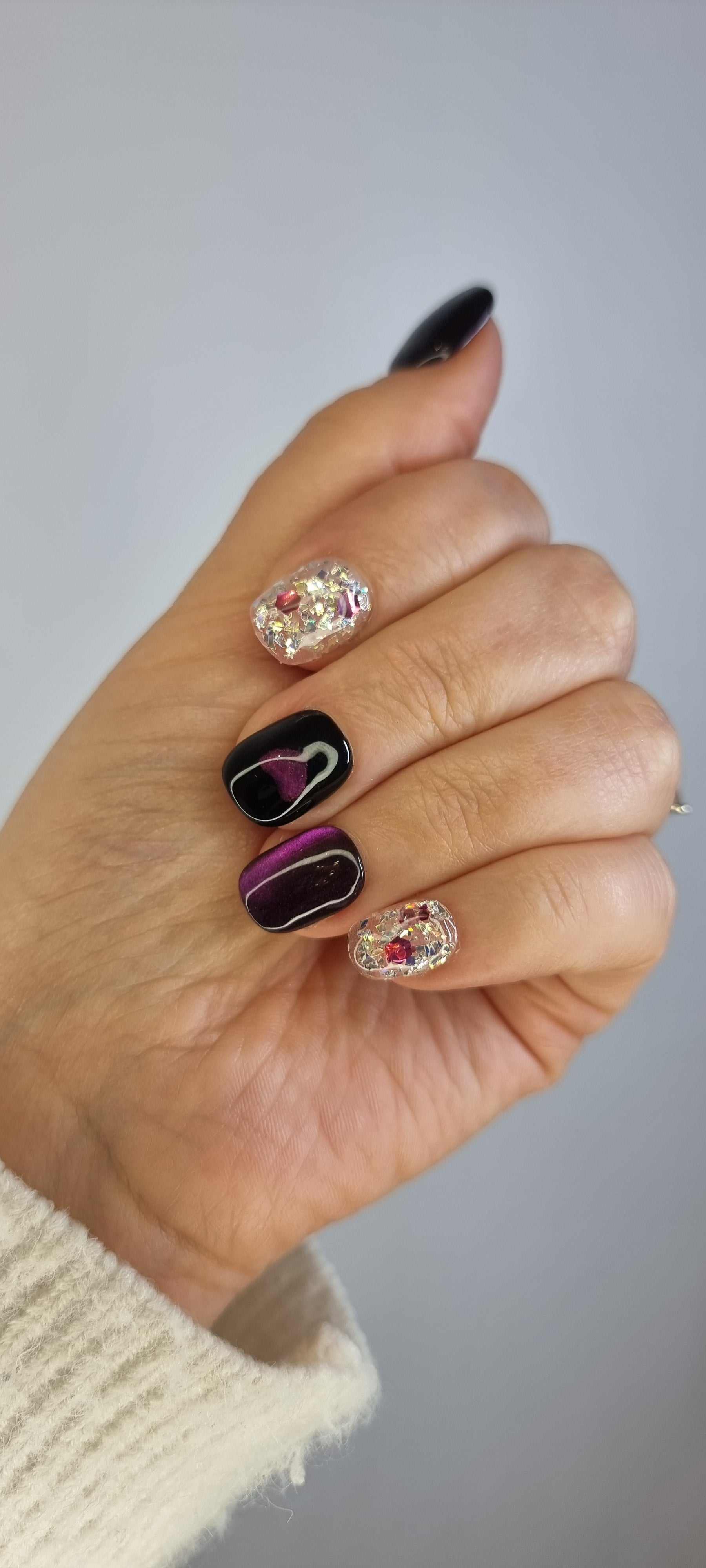 Set of Yas Island false nails with a dark, abstract design, showcasing the full manicure.