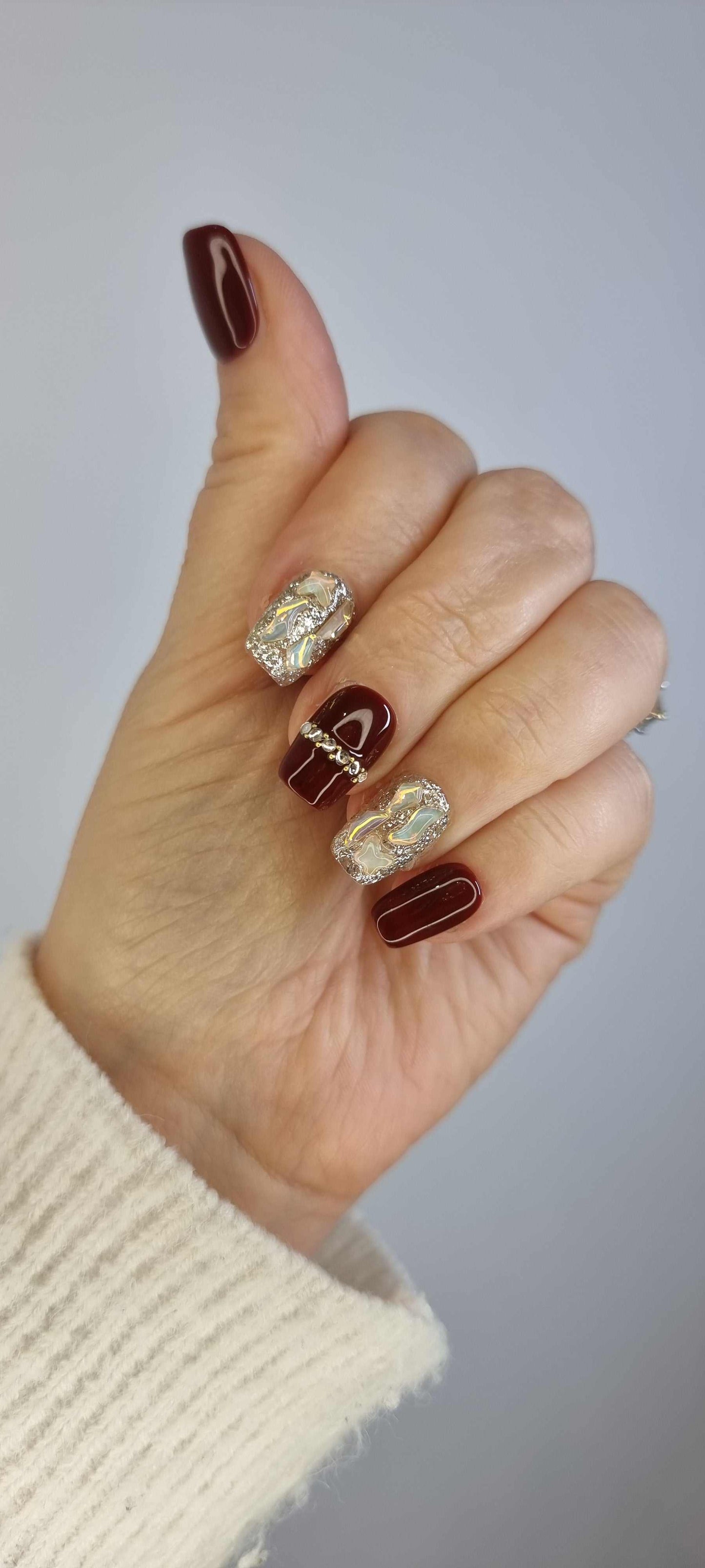 Close-up of a hand wearing the Zaina red short square press-on nails.