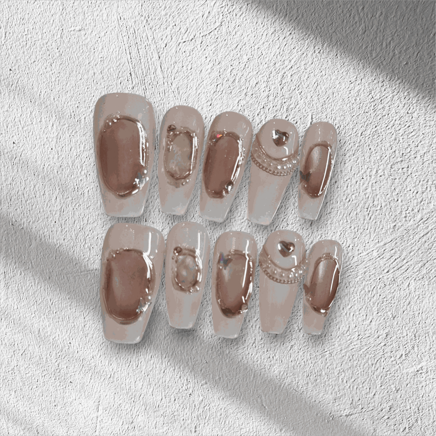 Full set of Zaynah Long neutral-toned, glossy coffin-shaped press-on nails in the box.