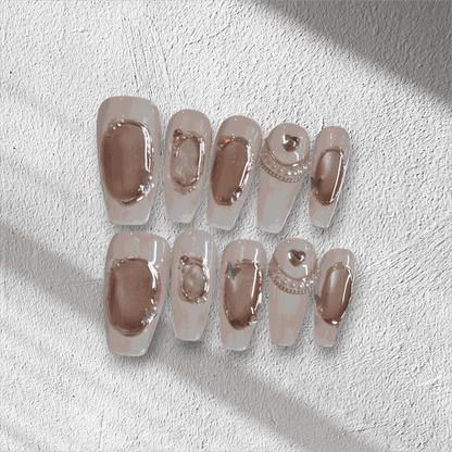 Full set of Zaynah Long neutral-toned, glossy coffin-shaped press-on nails in the box.