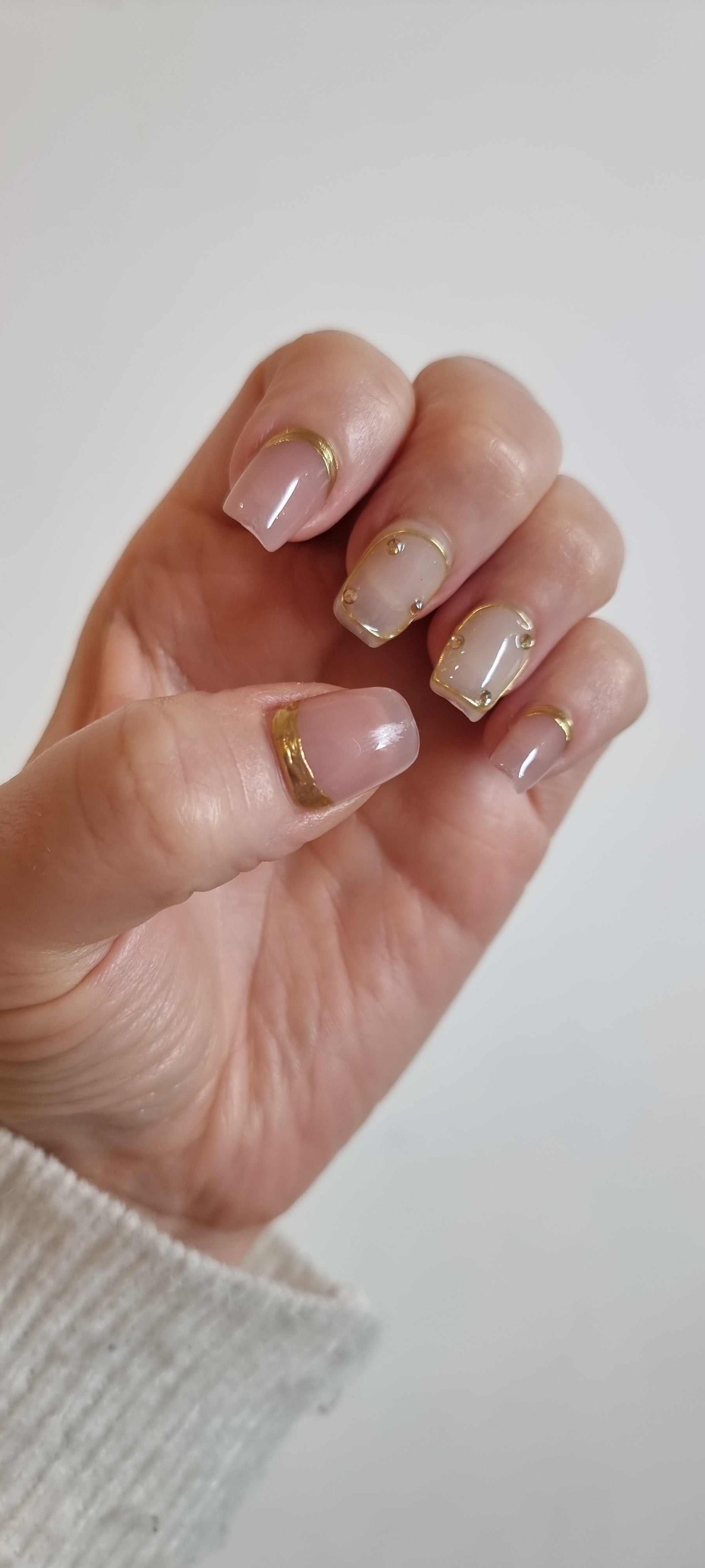 A set of Zina nude artificial nails with a glossy finish, showing the manicure application.